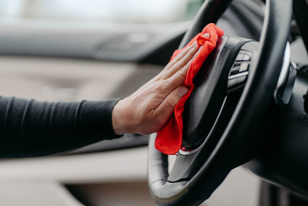 man using a steering wheel cleaner